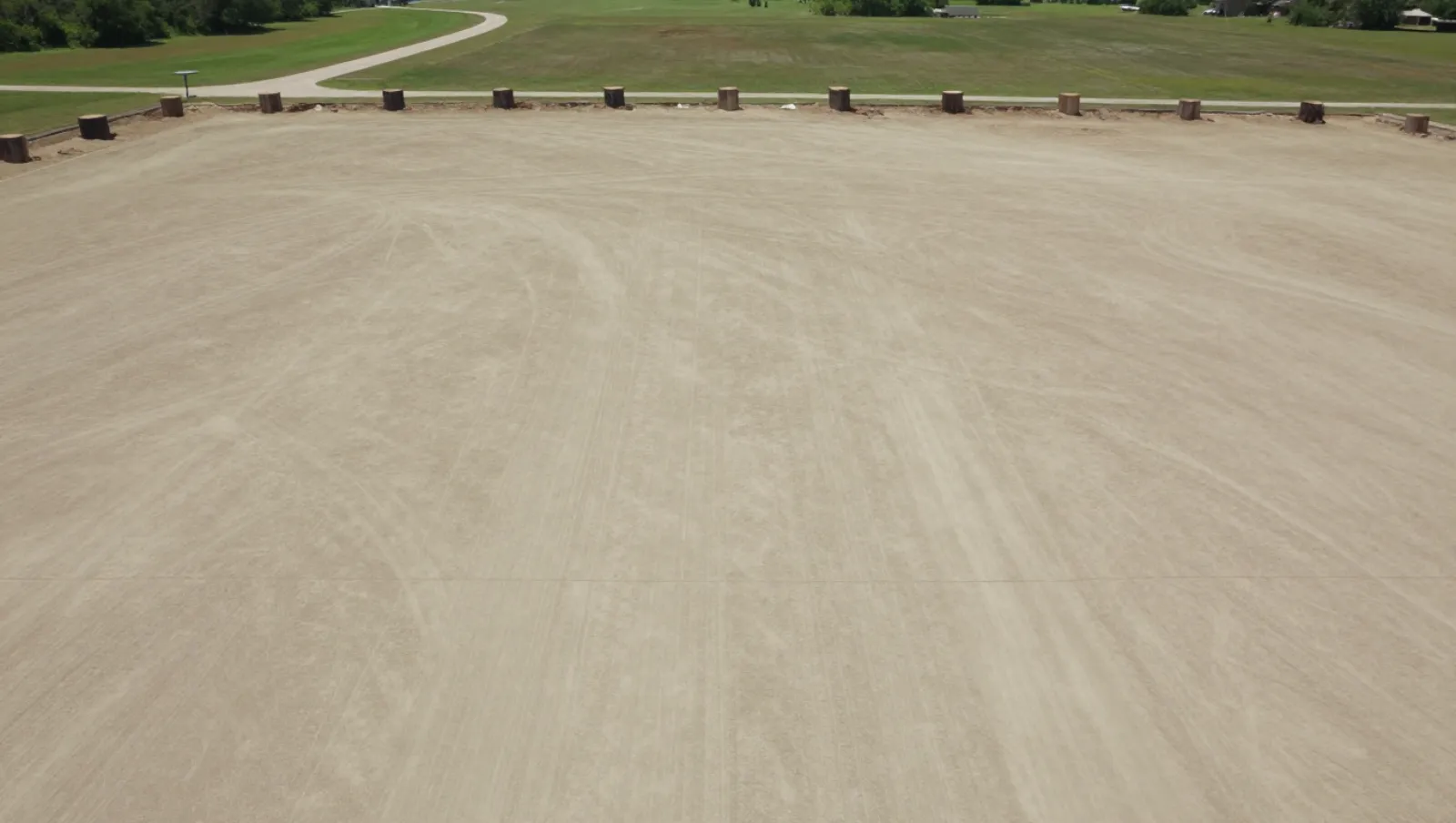 Sandy terrain has wooden posts and tire marks from heavy machinery during site preparation — Daniel Dean Land Clearing, Southeast Texas