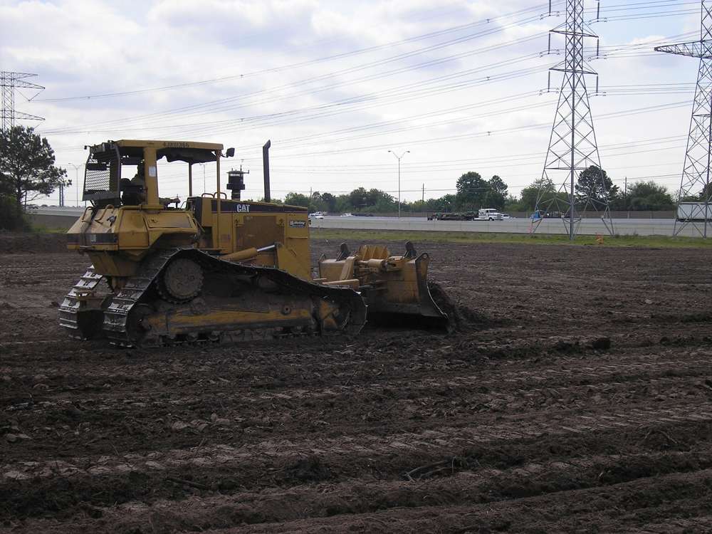 Commercial land clearing with heavy equipment removing vegetation